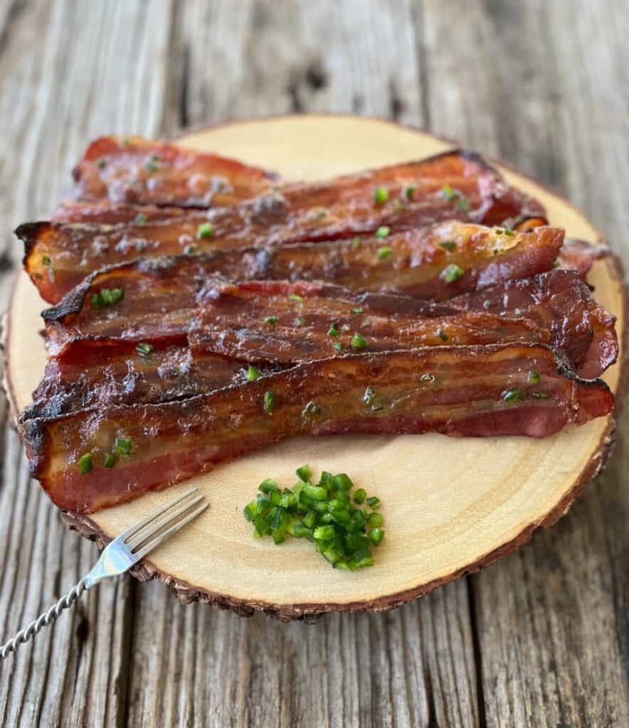 Strips of bacon on a round piece of wood