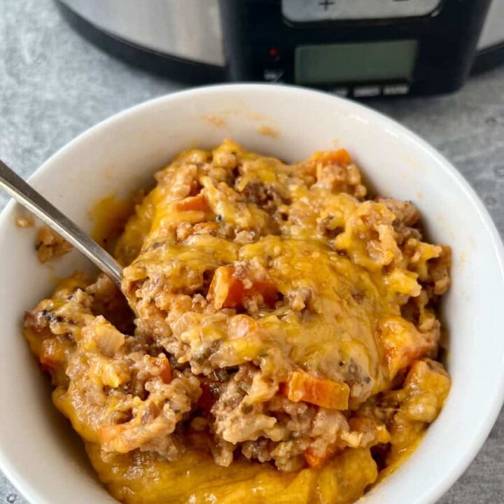 White bowl with ground pork casserole. There is a spoon in the bowl