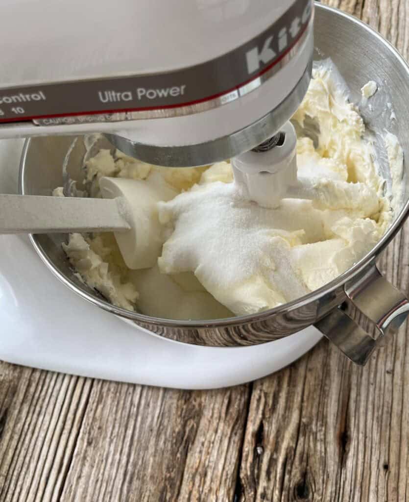 A mixer is being used to make a cream cheese mixture.