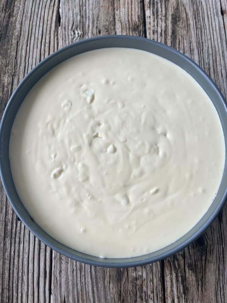 A pan of white batter on a wooden table.