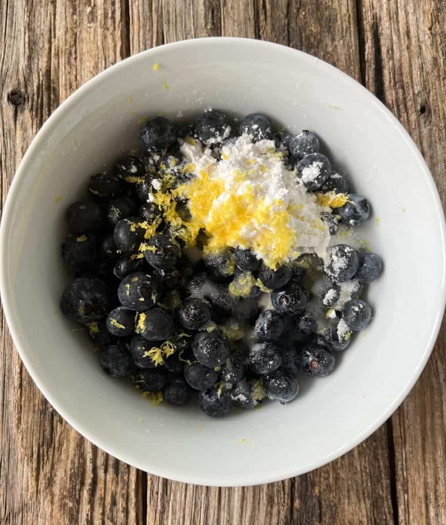 Blueberries and lemon in a bowl.