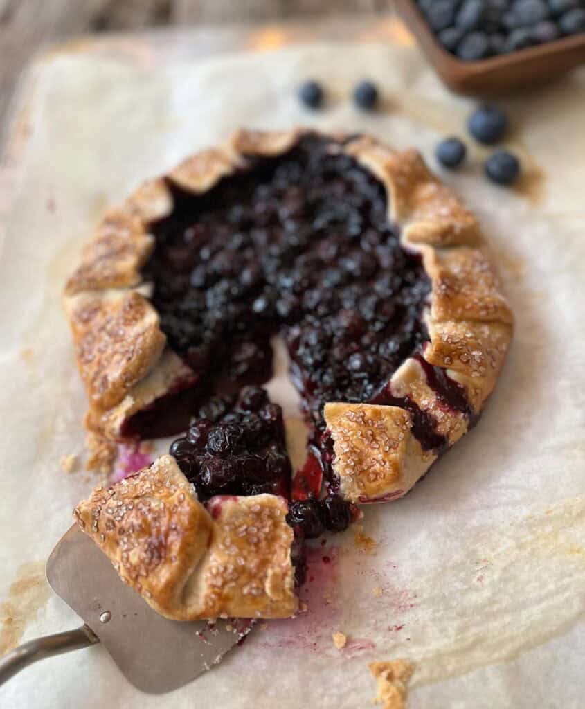 A blueberry pie with a metal pie server.
