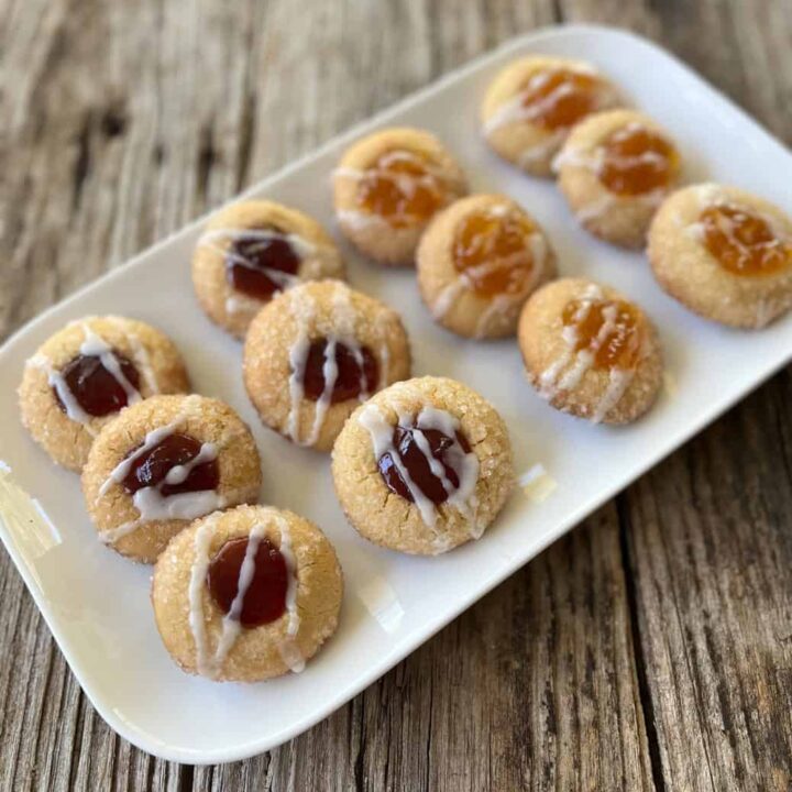 A plate of cookies with jam on top.