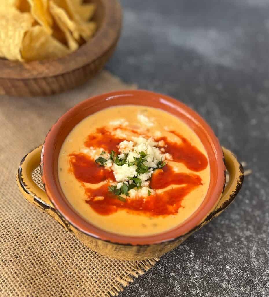 Mexican queso sauce in a bowl with chips.