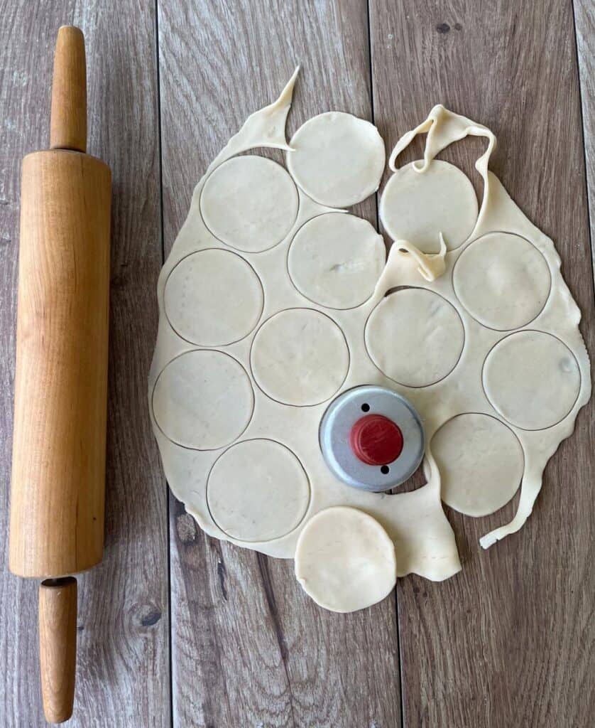 A rolling pin and dough on a wooden table.