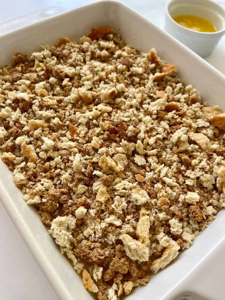 A casserole dish filled with chicken, sauce, and bread cubes.