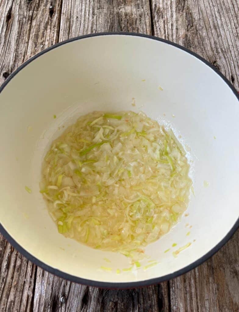A pot with some chopped onions cooking in it.