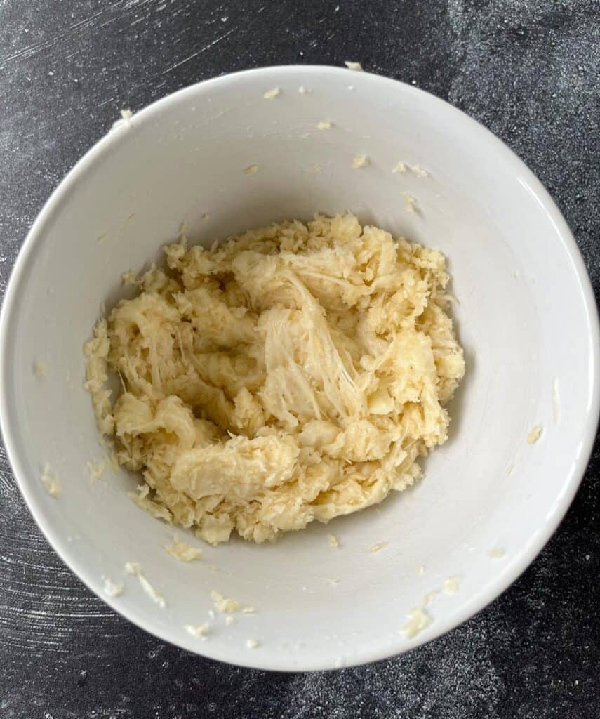 A bowl of a melted cheese mixture in it.