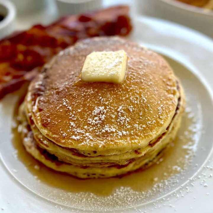 A stack of pancakes with butter and syrup on top.