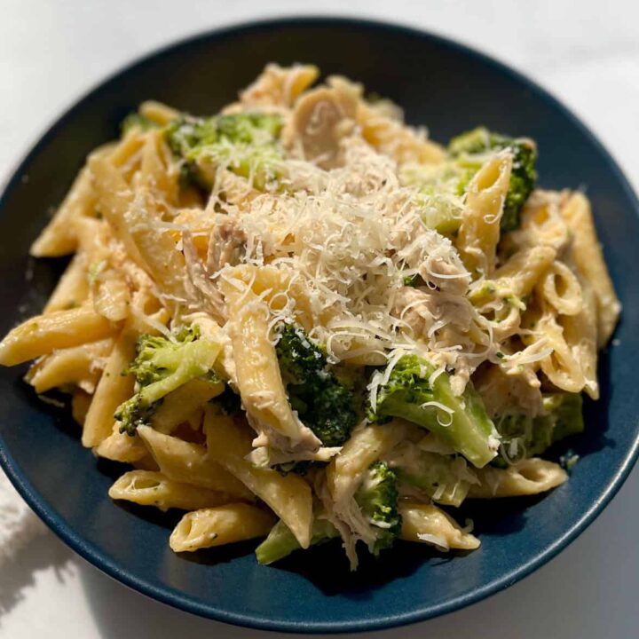 Chicken and broccoli pasta in a blue bowl.