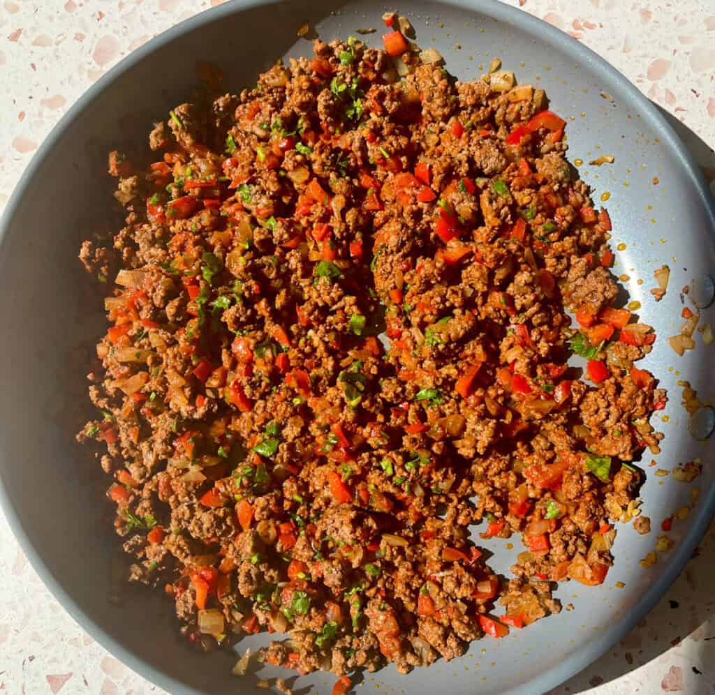 A pan filled with ground beef and vegetables.