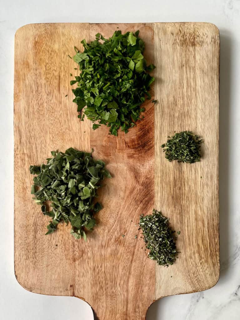 Chopped herbs on a cutting board.