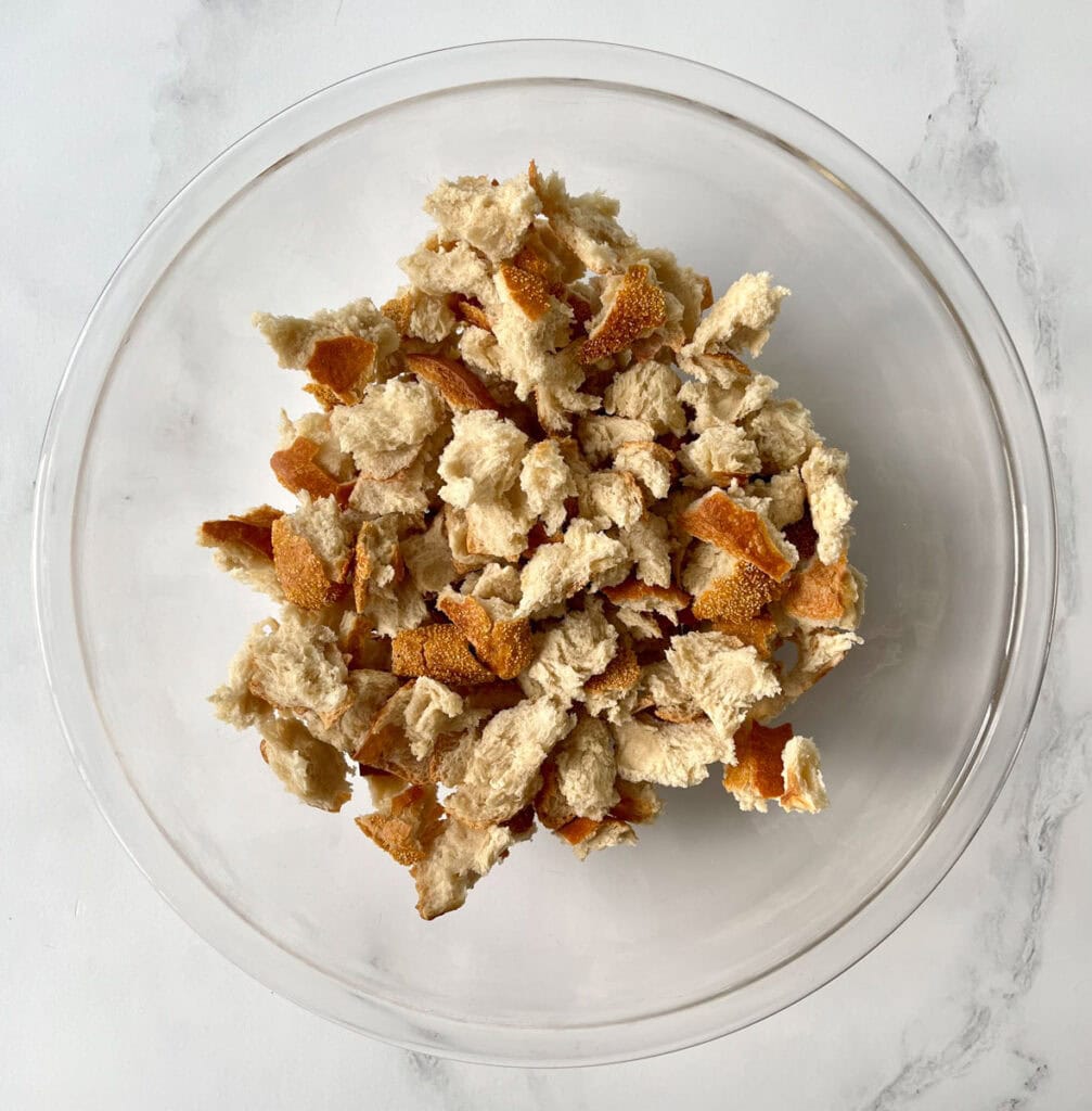 A bowl of crumbled bread in a clear bowl.