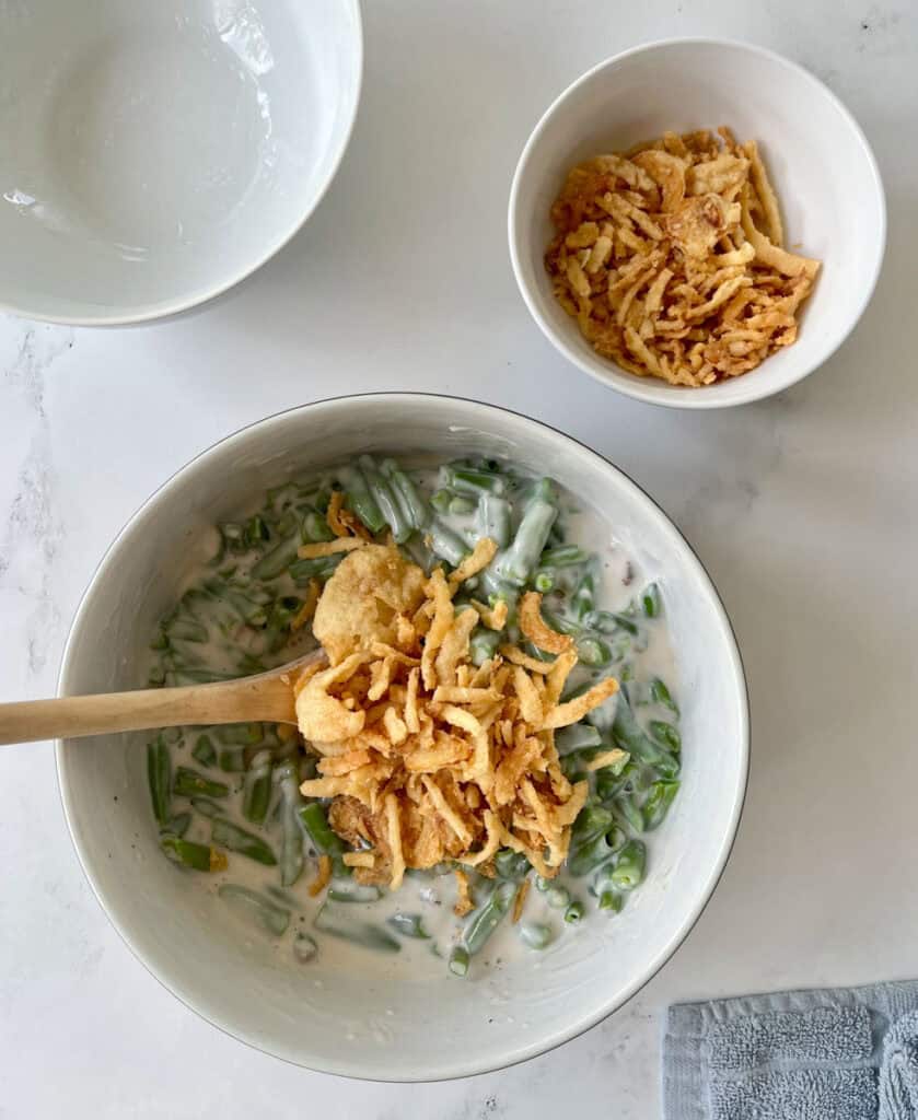 A bowl of green beans and a bowl of fried onion.