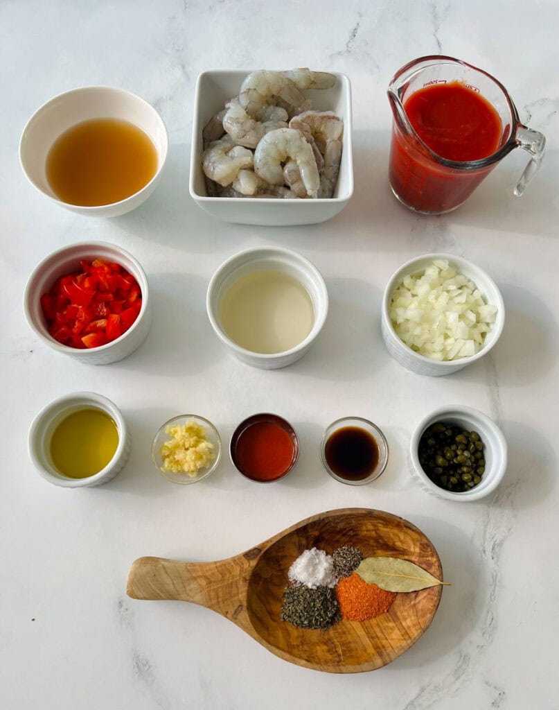 Ingredients for shrimp creole on a white counter.
