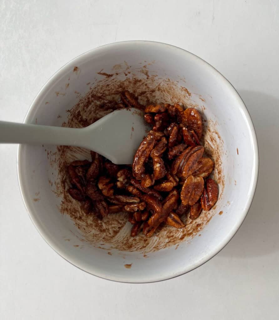 A bowl filled with nuts and a spoon.