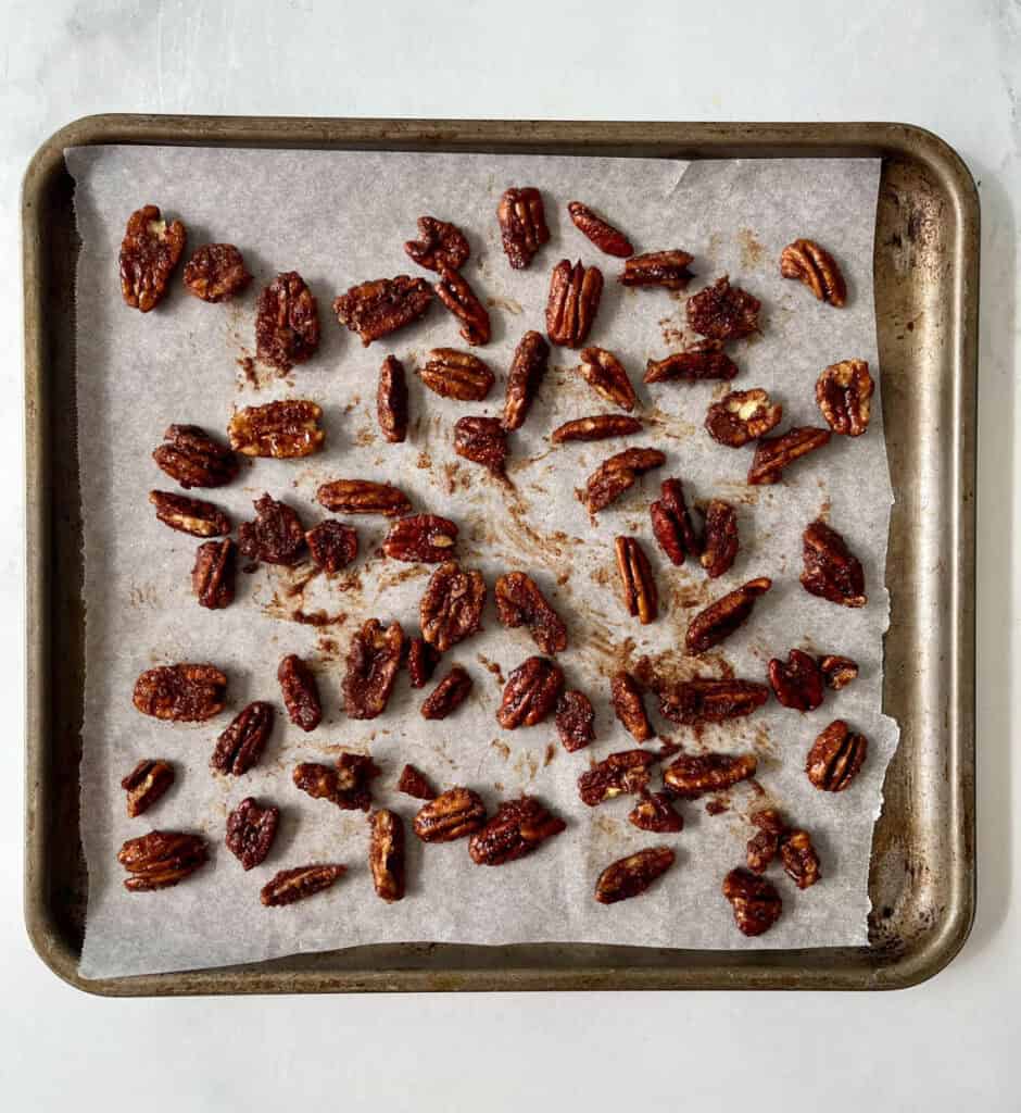 A baking sheet filled with candied pecans.