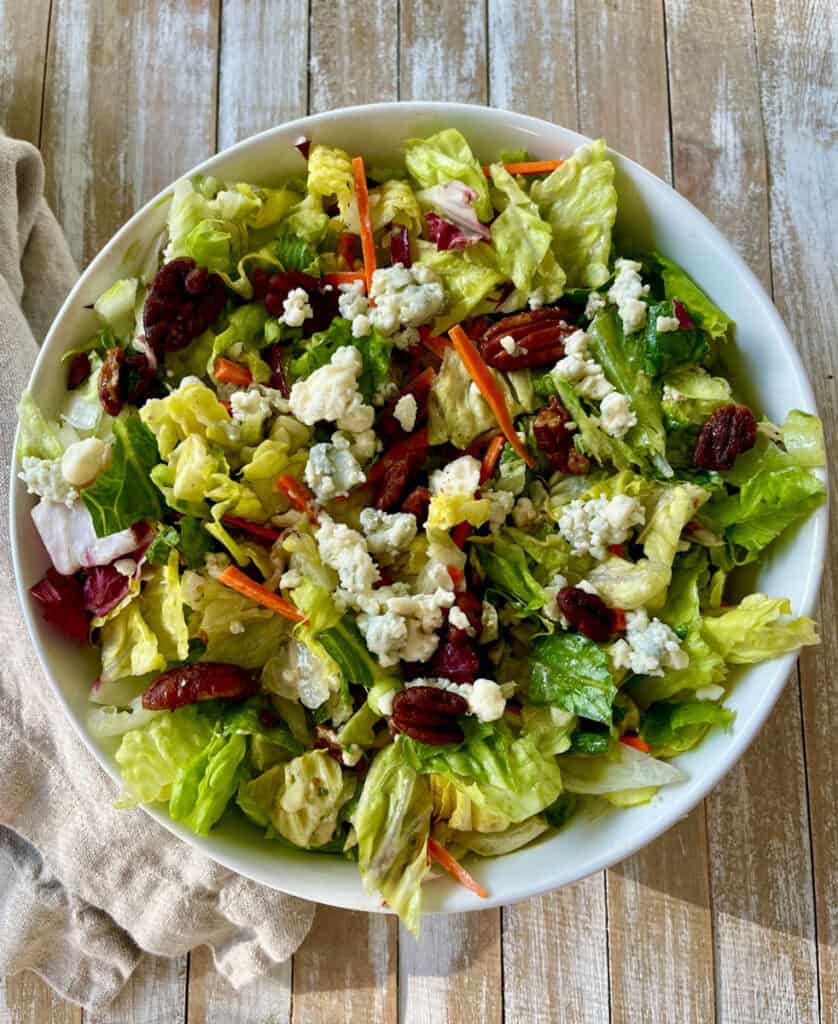 A salad with lettuce, carrots, and cheese in a bowl.