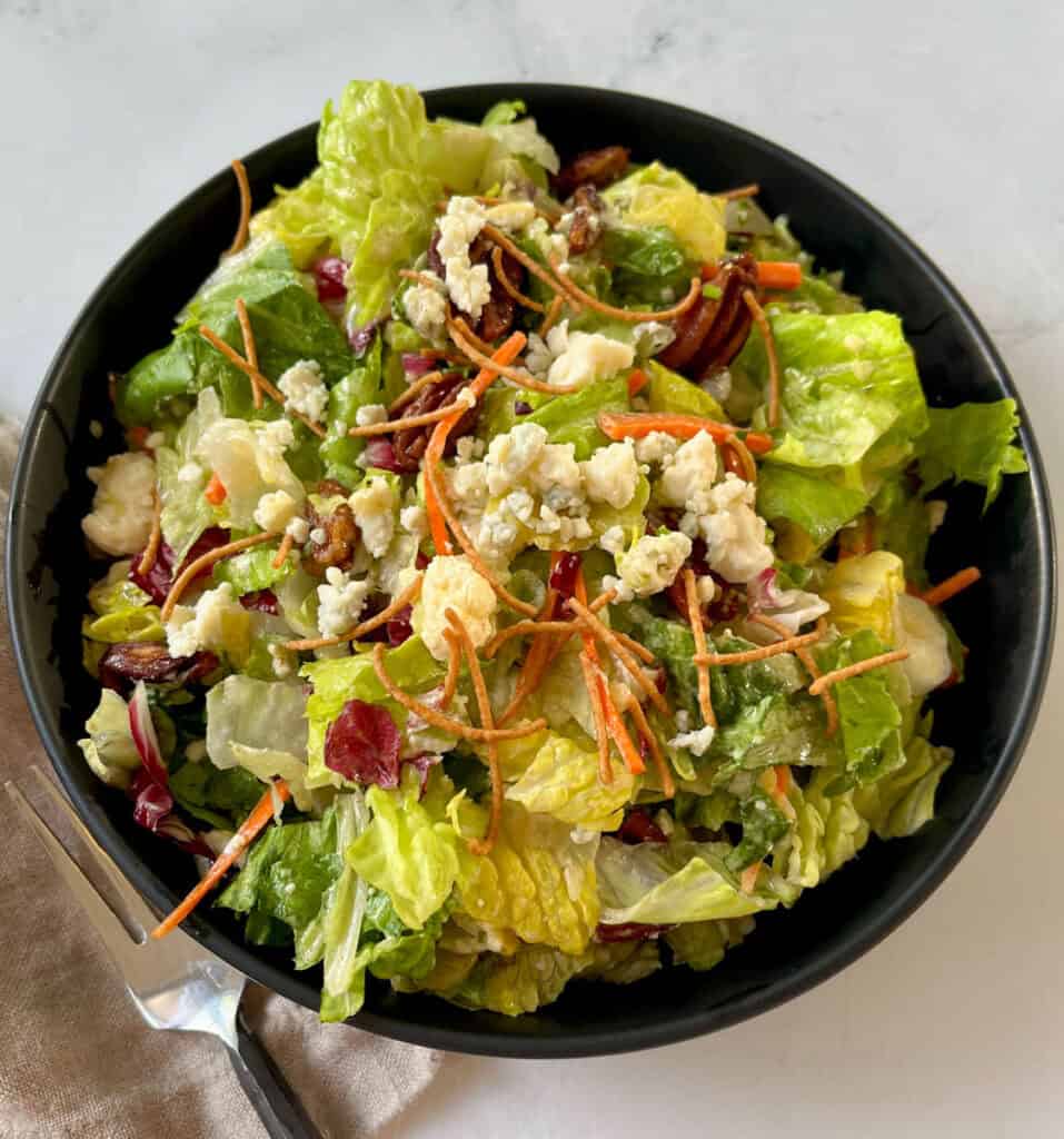 A salad with lettuce, carrots, and cheese in a bowl.