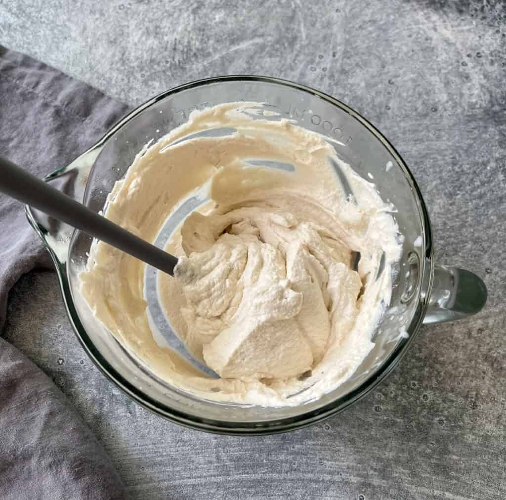 A bowl of whipped cream with a spoon.