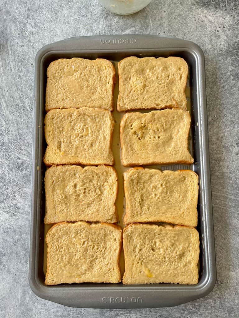 A pan filled with slices of bread dipped in batter.