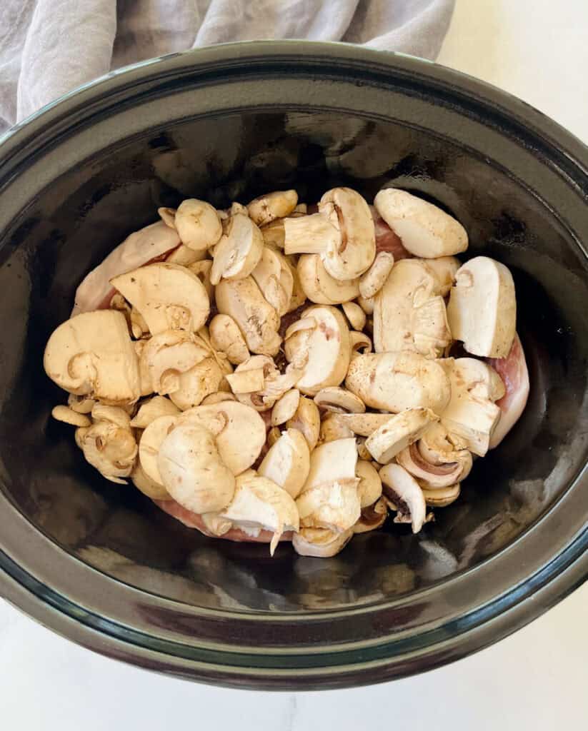 Slow cooker with pork chops and mushrooms.