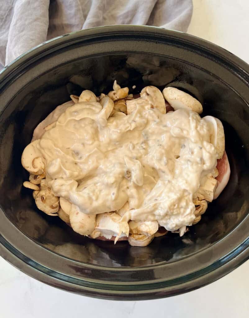 Pork chops, mushrooms and condensed soup in a slow cooker.