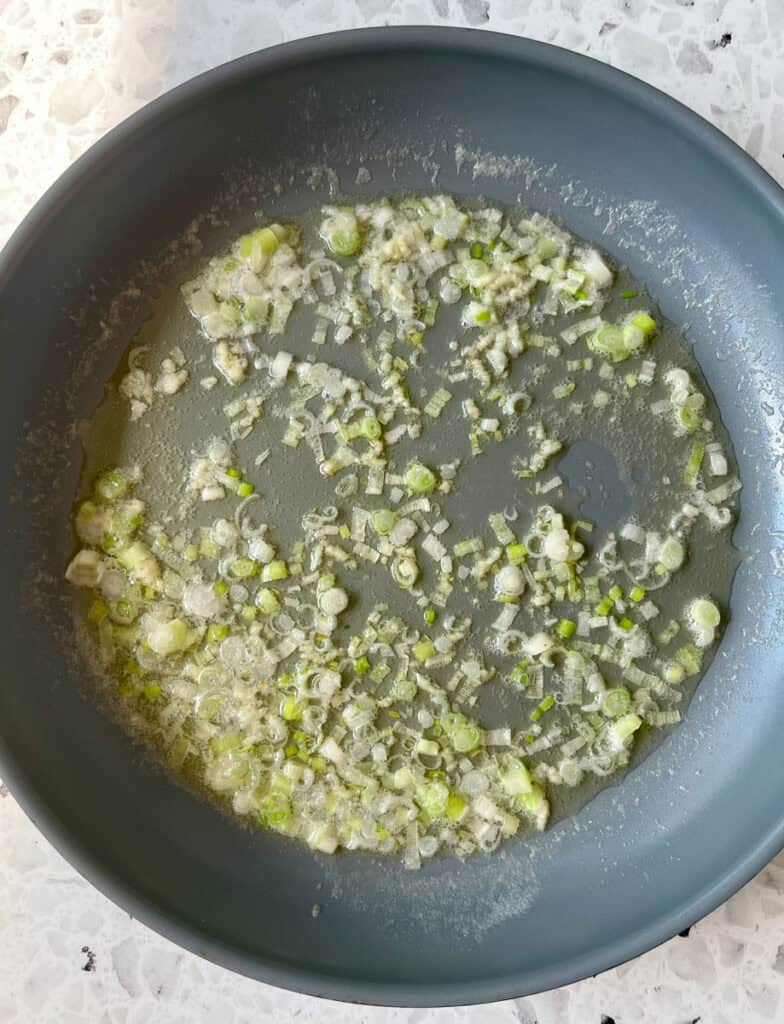 A pan filled with chopped onions and garlic.
