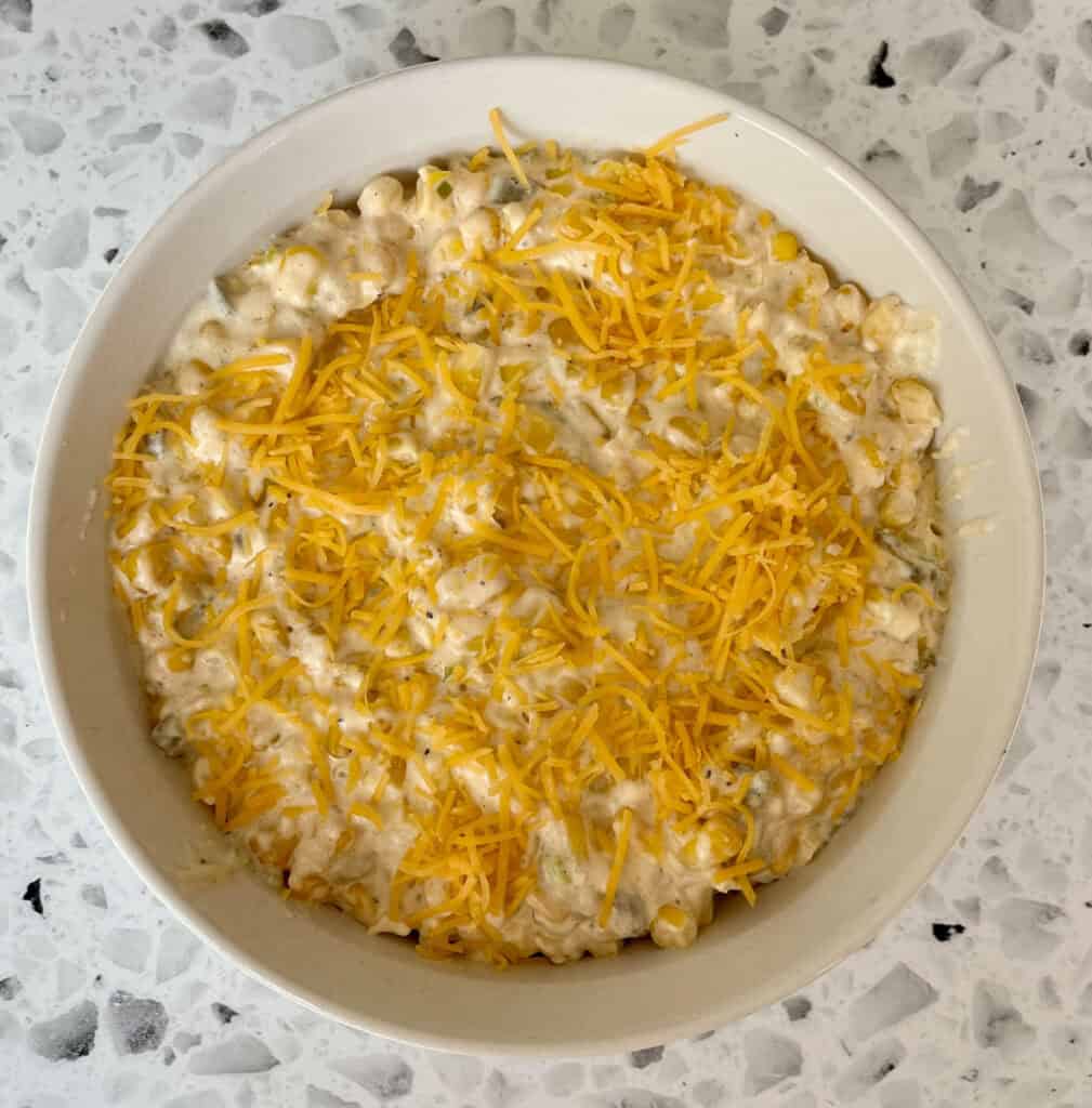 A baking dish with corn and cheese on top.