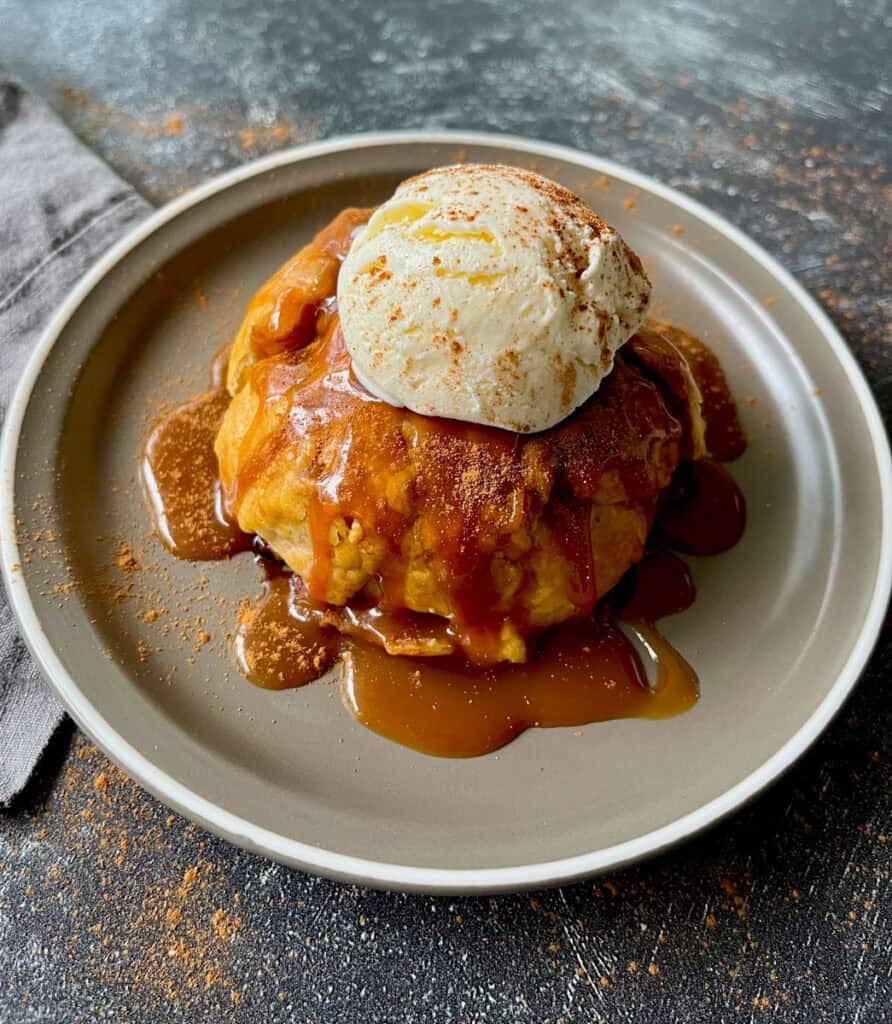 A plate topped with a pancake and ice cream.