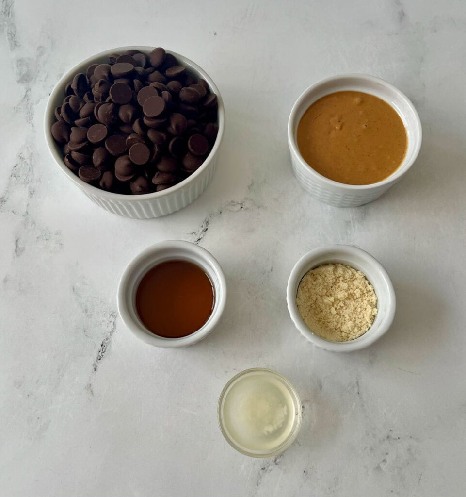 Chocolate chips, peanut butter, and other ingredients on a white surface.
