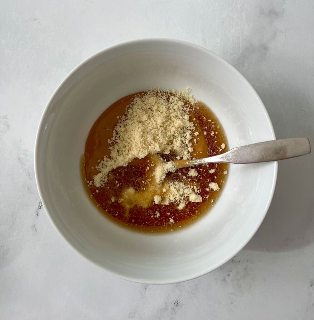 A bowl of peanut butter mixture with a spoon in it.