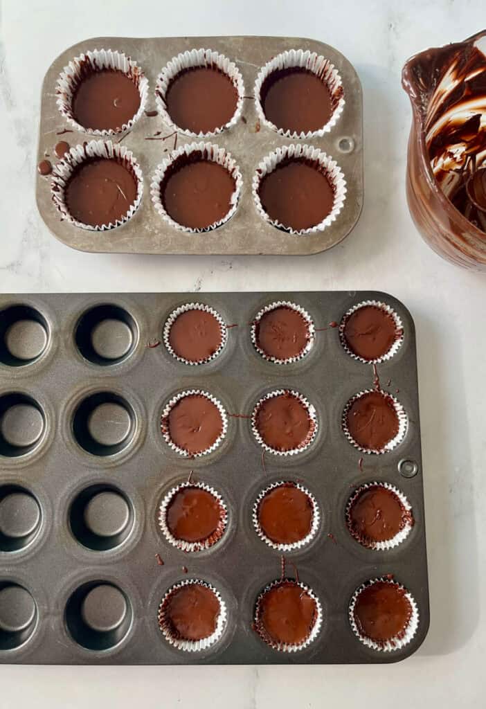 Chocolate peanut butter cups in a muffin tin.