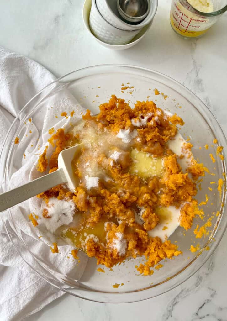A bowl filled with mashed sweet potatoes and other ingredients.