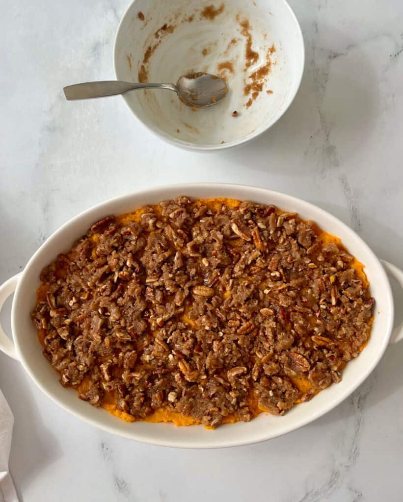 Unbaked sweet potato casserole in a white dish.