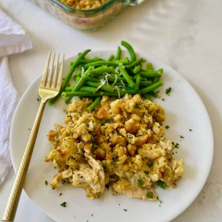 Creamy chicken casserole with green beans on a white plate.