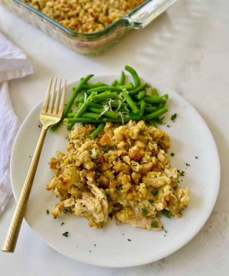 Creamy chicken casserole with green beans on a white plate.