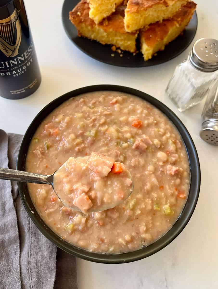 Creamy homemade bean soup with fresh vegetables and ham with toasted cornbread on the side. Perfect comfort food.