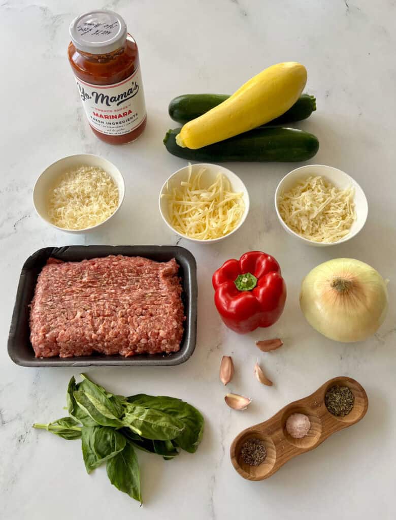Vegetables, ground sausage, shredded cheese, and seasonings for a casserole.