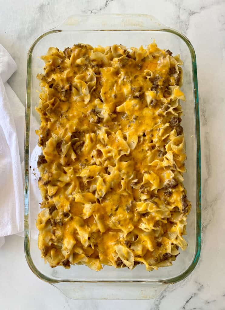 Cheesy beef pasta casserole in a glass dish, baked to golden perfection.