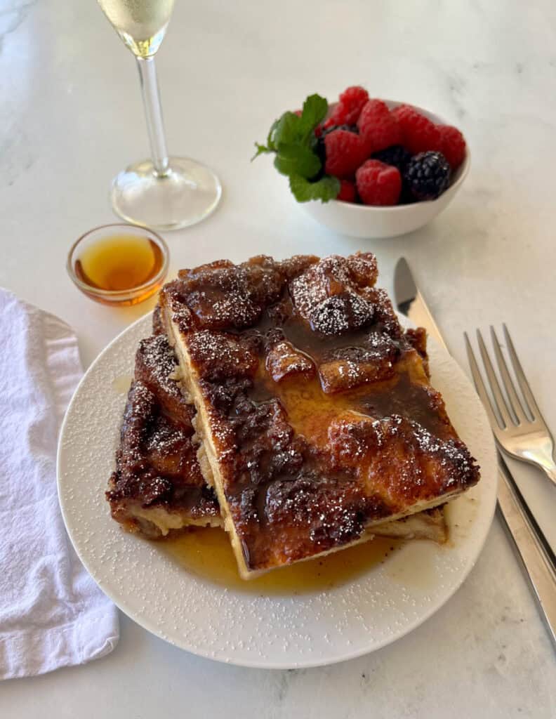 Delicious French toast topped with caramelized fruit and syrup, served with fresh berries.