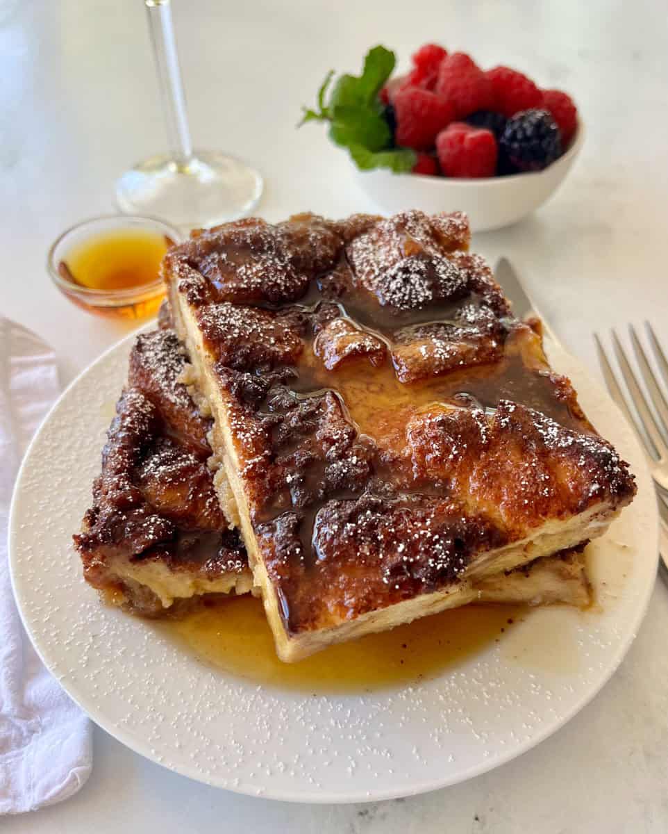 Delicious French toast topped with syrup and powdered sugar, served with fresh berries on the side.