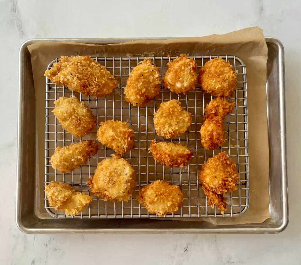 Golden crispy sea scallops on a wire rack.