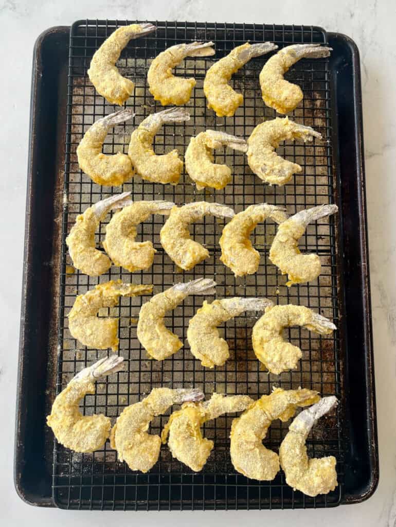 Crispy breaded shrimp cooling on a wire rack, ready to serve or enjoy as a delicious appetizer.