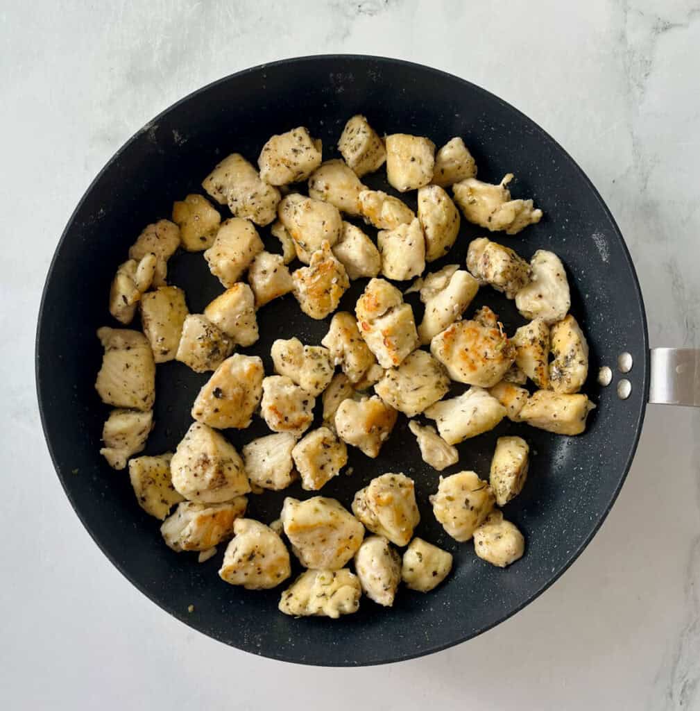 Cooked chicken pieces in a black skillet, ready to serve.