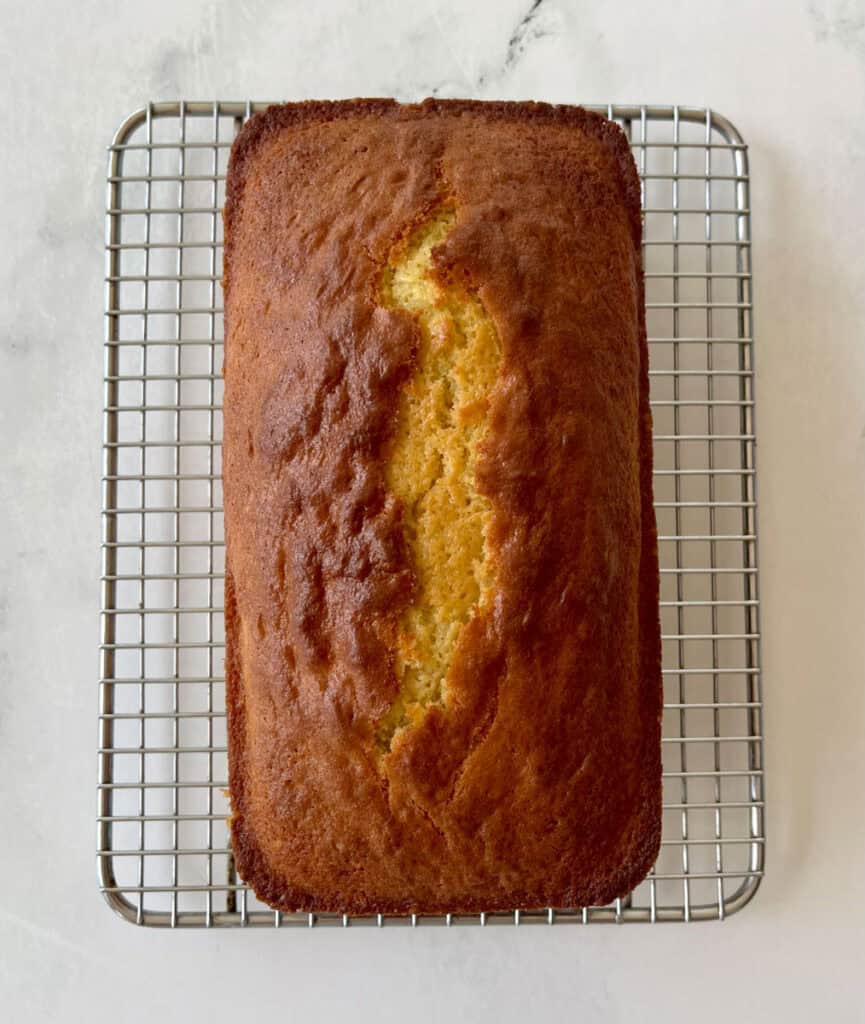 Freshly baked lemon loaf on a wire cooling rack.
