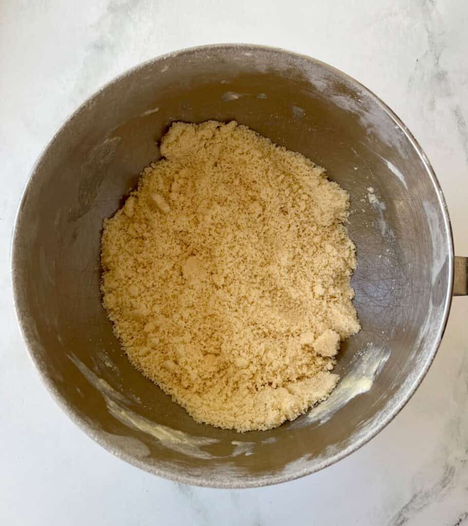 Crust dough ready for baking in a metal mixing bowl.