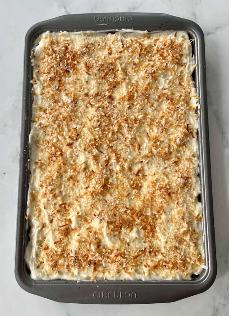 Pineapple bars with toasted coconut topping in a baking dish.