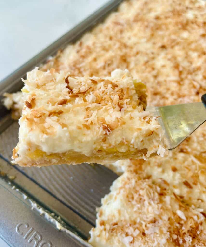 Pineapple bars with toasted coconut topping in a baking dish.