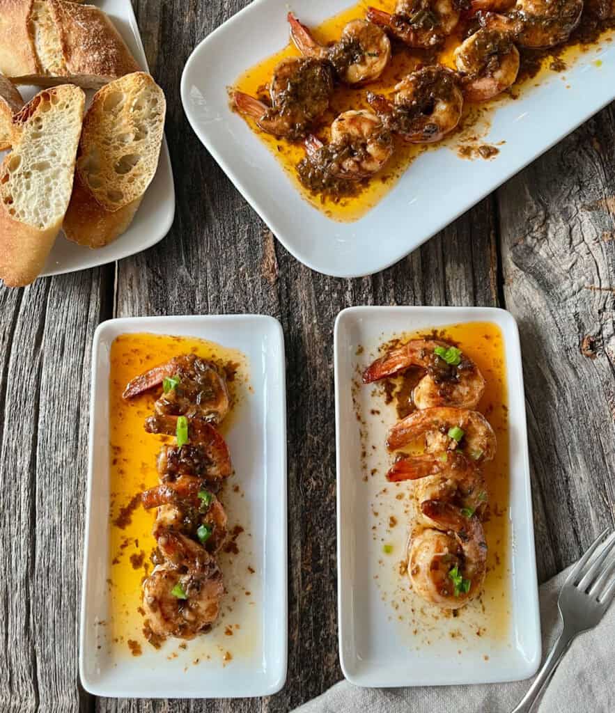 Shrimp served with spicy sauce and fresh bread on rustic wooden table.